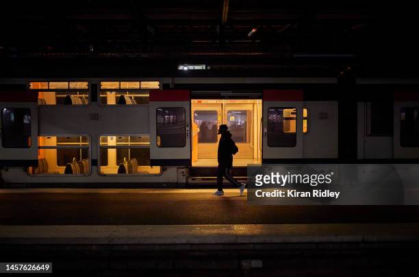 Passenger walks past an empty suburban train at Gare de l'Est Railway Station in Paris as France is hit by widespread traffic disruption as transport...