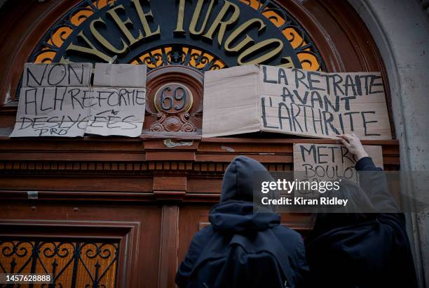 High School students put up a placard that reads "Retirement before Arthritis" at the entrance to Lycee Turgot as part of a nationwide strike against...