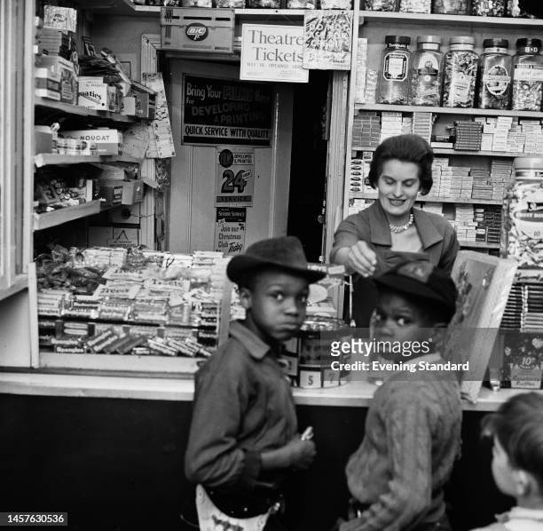 Two boys in a sweet shop in De Beauvoir Town, Hackney, London, where they are being served by a woman named as Mrs Green on November 7th, 1960.