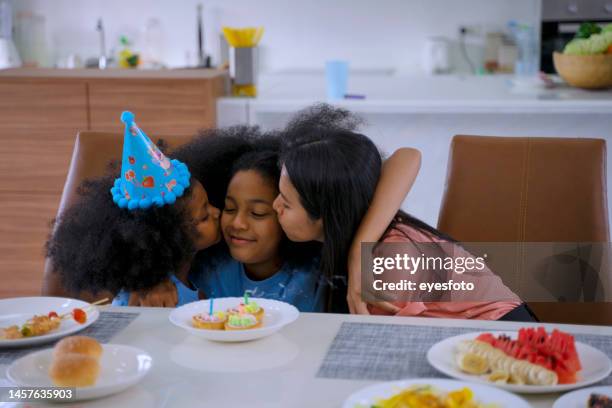 la mamma e le due figlie stanno festeggiando per il giorno della nascita. - parents children blow candles asians foto e immagini stock