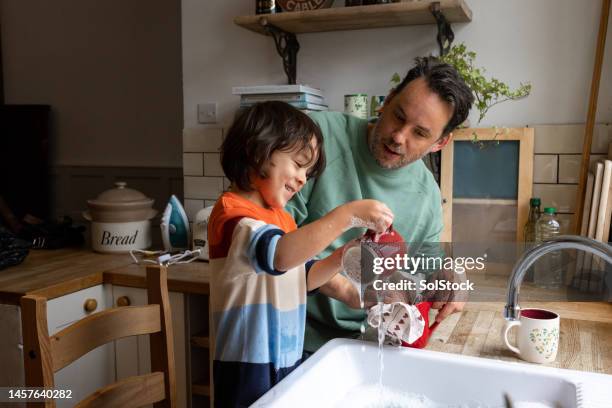 moments together with son - washing dishes stock pictures, royalty-free photos & images