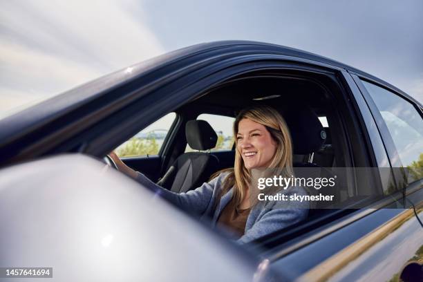 femme heureuse appréciant tout en conduisant une voiture. - driving photos et images de collection