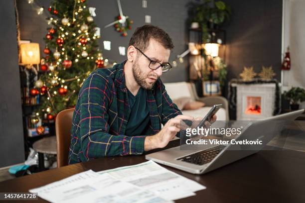 man reviews finances in time for the new year - finance and economy stock pictures, royalty-free photos & images