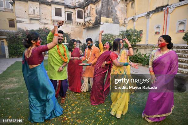 group of indian men and women in traditional wear dancing and celebrating holi festival in the courtyard of a palace in rajasthan - rajasthan dance stock pictures, royalty-free photos & images