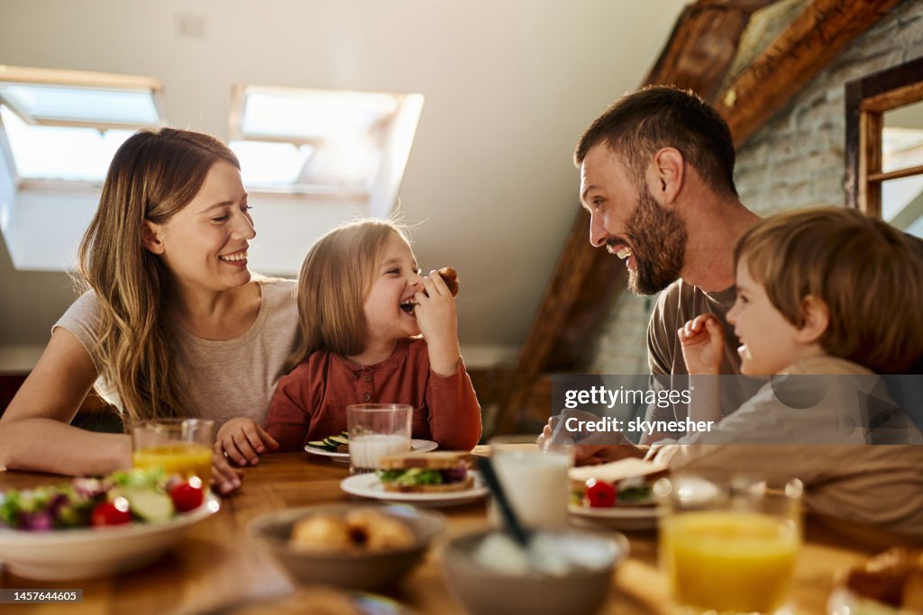 Young family talking during breakfast at dining table.