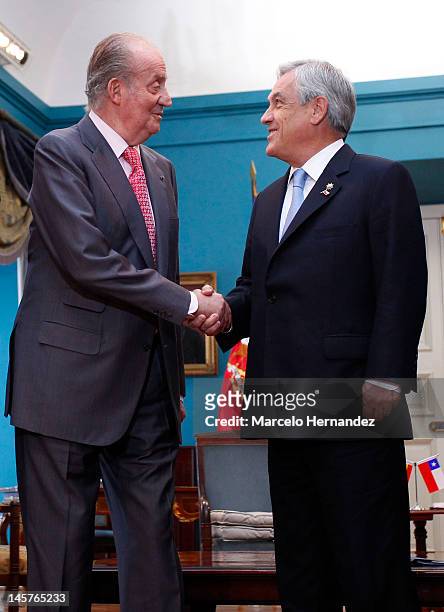 King Juan Carlos of Spain and the President of Chile Sebastián Piñera shake hands during the visit to the Presidential Palace La Moneda on June 5,...
