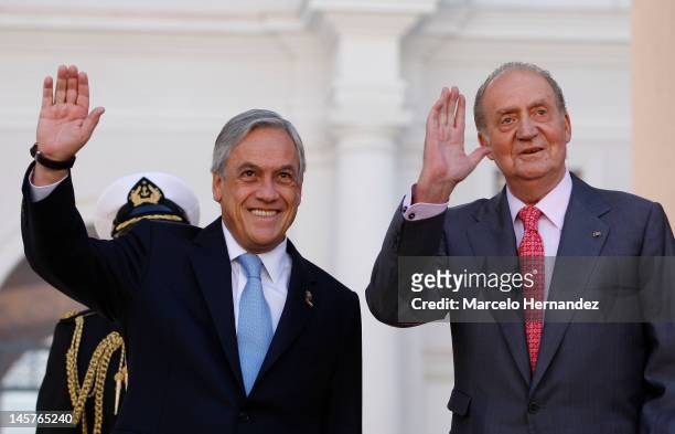 King Juan Carlos of Spain and the President of Chile Sebastián Piñera greet people during the visit to the Presidential Palace on June 5, 2012 in...