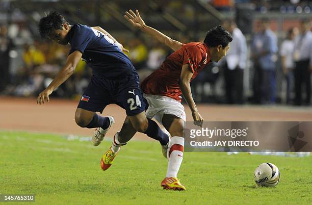 Philippine midfielder Marwin Angeles fights for the ball with Indonesia's forward Irfam Bachdim during a friendly football match at the Rizal...