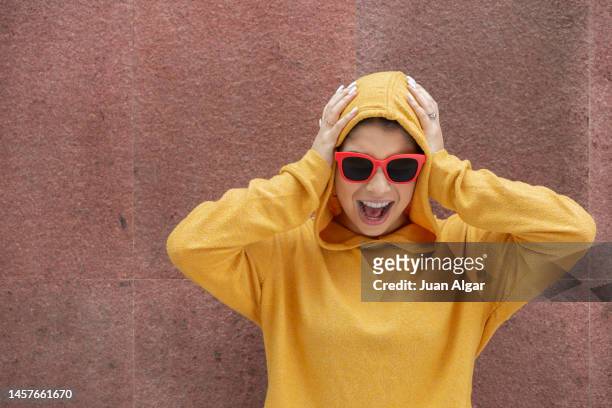 joyful teenage girl rejoicing over success touching head - hands behind head stock pictures, royalty-free photos & images