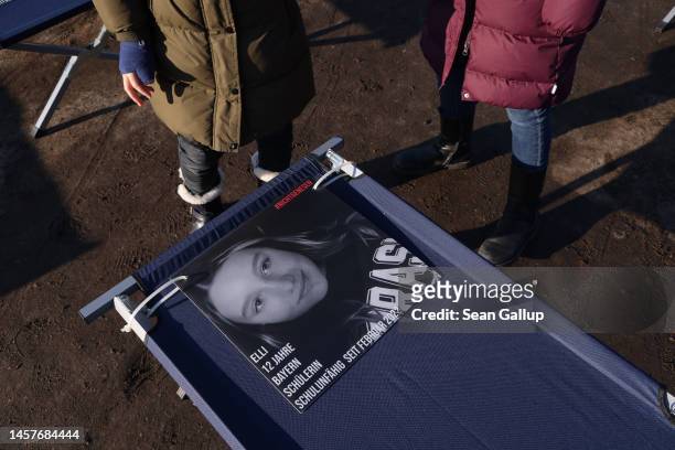 Children look at a photograph depicting Elli, 12 years old, whom the text describes as a schoolchild from Bavaria who has been unable to attend...