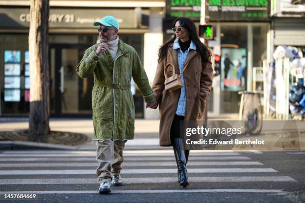 Guest wears a green cap, a white latte wool turtleneck pullover, a green belted long coat, khaki denim pants, white latte leather with gray toe cap...