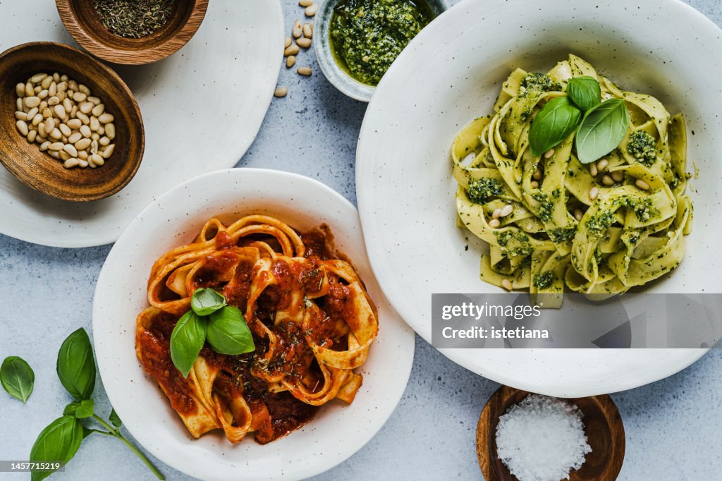 Tomato pasta and pasta with basil pesto sauce, healthy vegan dish viewed from above