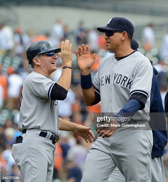 First base coach Mick Kelleher and Alex Rodriguez of the New York Yankees high-five after the victory against the Detroit Tigers at Comerica Park on...