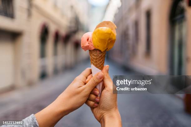 mujer joven sosteniendo helado en la calle en como - gelato italiano fotografías e imágenes de stock