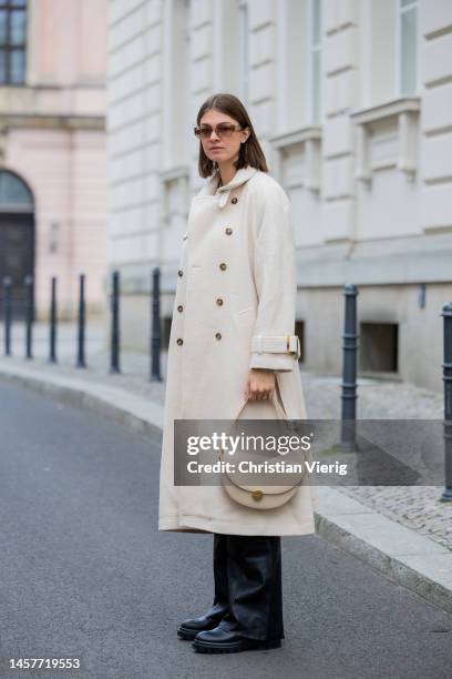 Jacqueline Zelwis wears creme double breasted Lovechild coat, Gant pullover, beige Agneel bag, Mads Norgaard leather pants, AGL Boots, Gigi Studios...