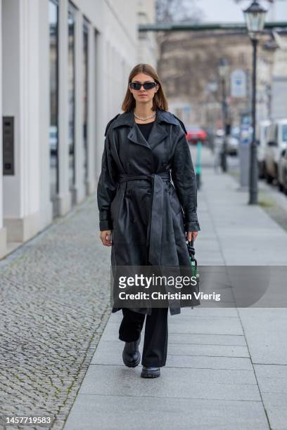 Jacqueline Zelwis wears black & other stories coat, black flared pants Lala Berlin, AGL boots, green Ganni bag during the Berlin Fashion Week AW23 on...