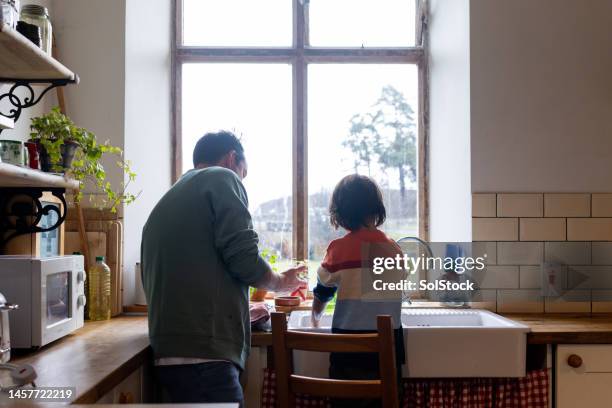 working as a team in the kitchen - asian father stock pictures, royalty-free photos & images