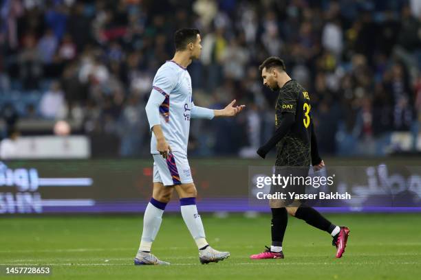 Lionel Messi of Paris Saint-Germain walks past Cristiano Ronaldo of Riyadh XI after scoring the side's first goal during the Winter Tour 2023...