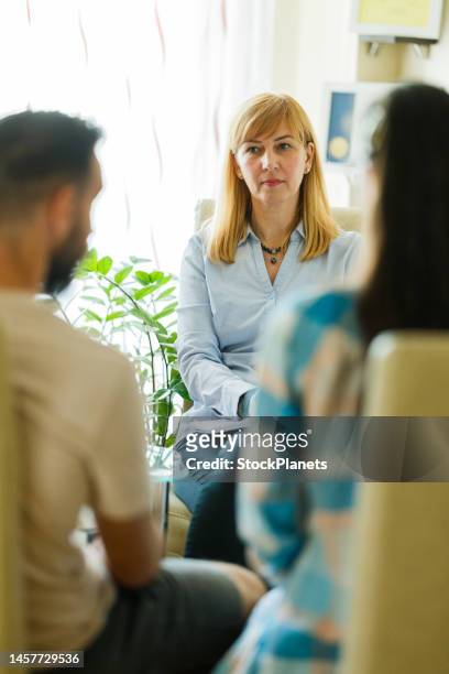 psychologist talking whit a couple in the office - couple counselling stock pictures, royalty-free photos & images