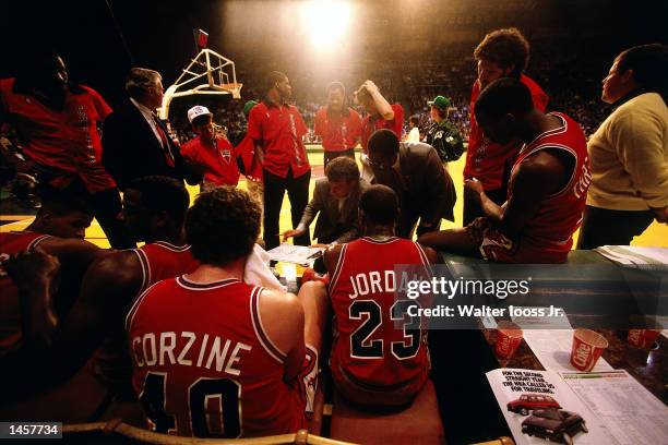 Michael Jordan of the Chicago Bulls listens to Head Coach Doug Collins draw up a play in1990 against the Milwaukee Bucks during a NBA game at The...