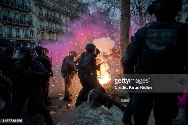 Firework explodes on French Riot Police as they detain a protestor as demonstrations turn violent as over 400,000 people take to the streets of Paris...