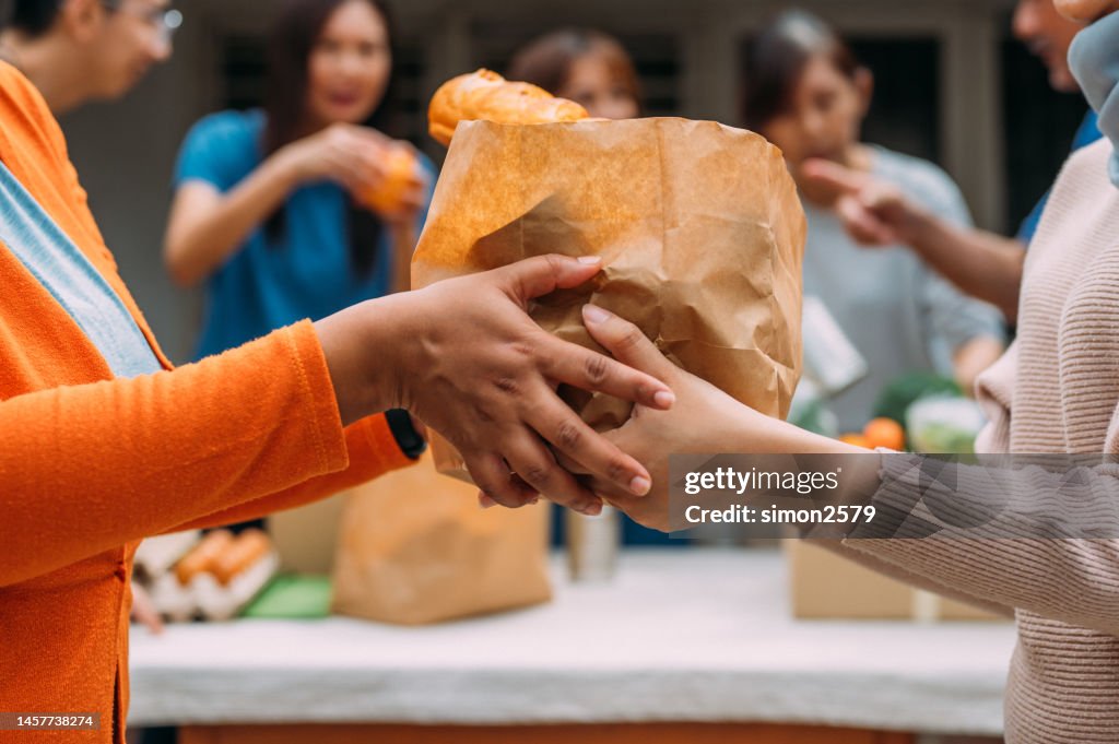 Mulher irreconhecível distribui doações de alimentos durante campanha beneficente