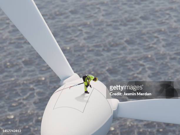 worker on wind turbine over sea - wind photos et images de collection