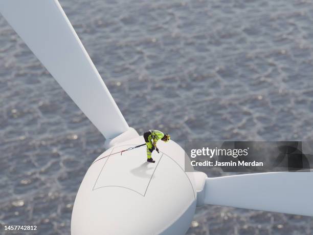 worker on wind turbine over sea - wind stock pictures, royalty-free photos & images