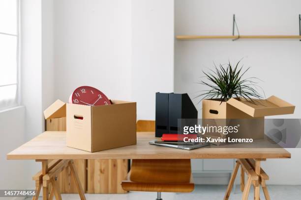 empty new office room with furniture and moving boxes. new business concept with modern desk with professional businessperson belongings on bright co-working workplace. start and beginning concept - secretária vazia imagens e fotografias de stock