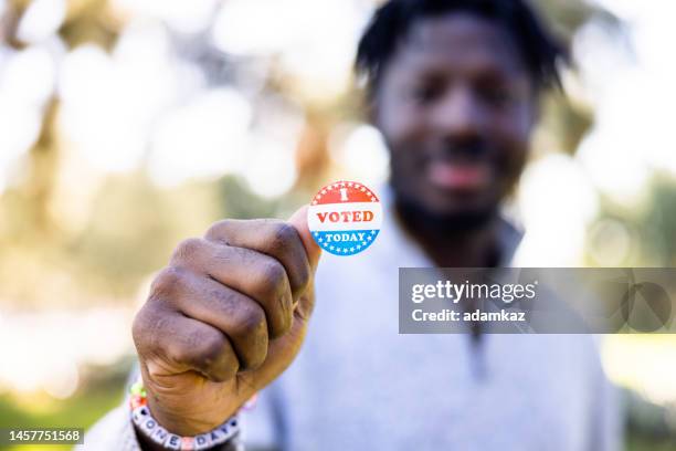 young black man with an i voted sticker for an election - vote sticker stock pictures, royalty-free photos & images