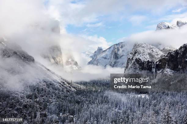 Recent snowfall rests on trees in Yosemite Valley as clouds begin to clear from the last of a series of atmospheric river storms to hit California on...