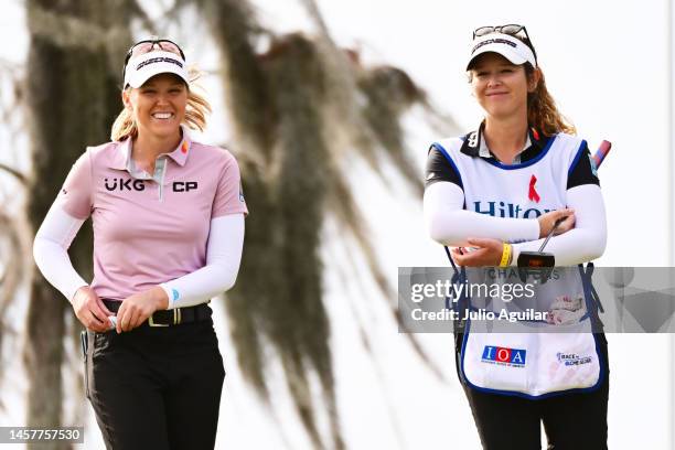 Brooke Henderson of Canada reacts with caddie Brittany Henderson after making her putt on the 18th green during the first round of the Hilton Grand...