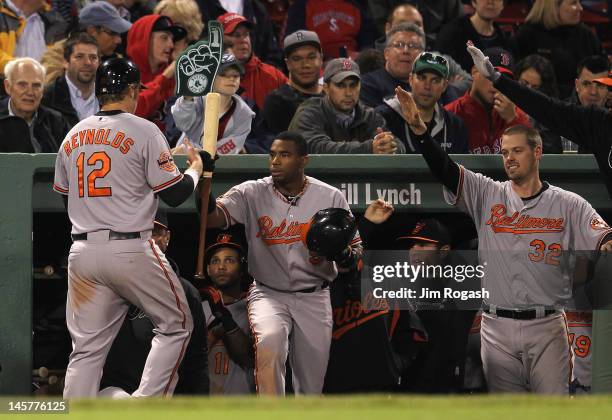 Mark Reynolds of the Baltimore Orioles celebrates with teammates after scored the winning on a hit by Ronny Paulino of the Baltimore Orioles in the...