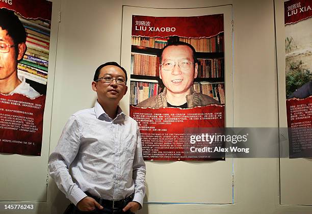 Chinese dissident and author Yu Jie poses for a picture in front of a poster of the 2010 Nobel Peace Prize winner Liu Xiaobo after an interview with...