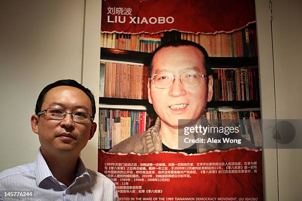 Chinese dissident and author Yu Jie poses for a picture in front of a poster of the 2010 Nobel Peace Prize winner Liu Xiaobo after an interview with...