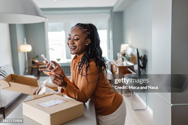 african-american woman is satisfied with internet order delivery - home convenience stock pictures, royalty-free photos & images