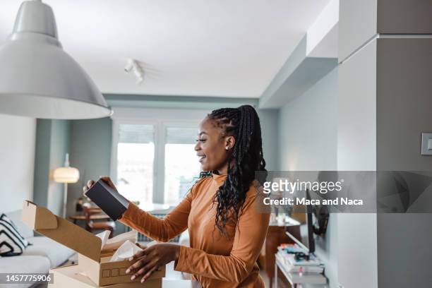 excited young woman opening her delivery - opening a box stockfoto's en -beelden