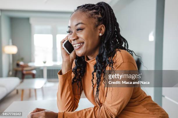 cheerful young woman talking on the phone - one person talking stock pictures, royalty-free photos & images