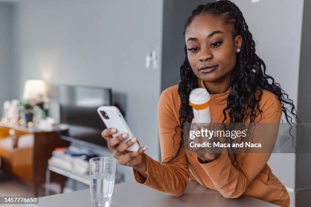 searching the internet about the correct use of medicine pills - prescription imagens e fotografias de stock