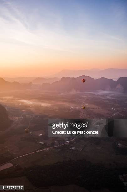 hot air balloons at sunrise - vang vieng balloon stock pictures, royalty-free photos & images