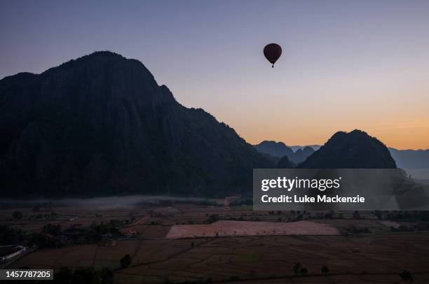 sunrise hot air ballooning vang vieng - vang vieng balloon stockfoto's en -beelden