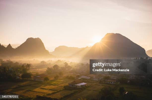 sunrise over farmland vang vieng - vang vieng balloon stock pictures, royalty-free photos & images