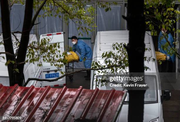 Funeral workers load bodies into vans to be taken for cremation at a busy local funeral home on January 13, 2023 in Shanghai, China.Chinas health...