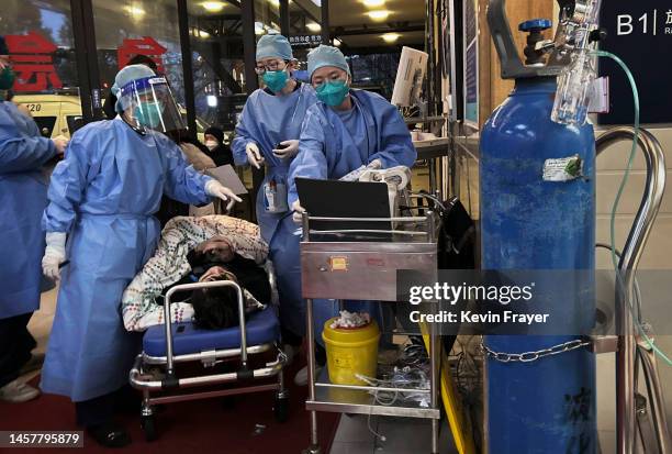 Medical staff triage a patient after being brought by ambulance at the entrance of a busy hospital on January 14, 2023 in Shanghai, China.Chinas...