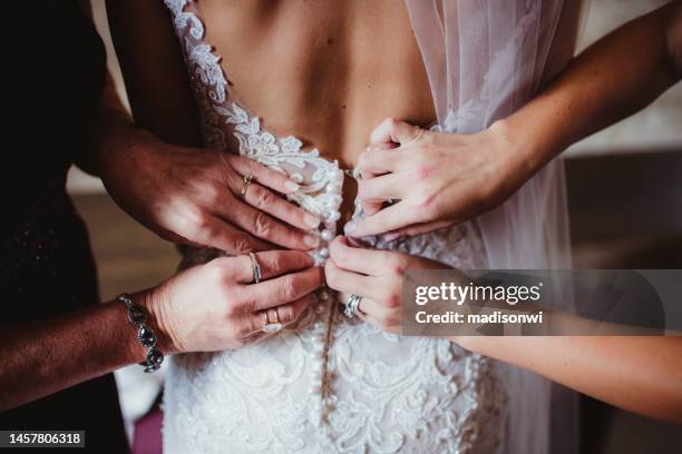 abrochar el vestido de bodas - vestirse fotografías e imágenes de stock