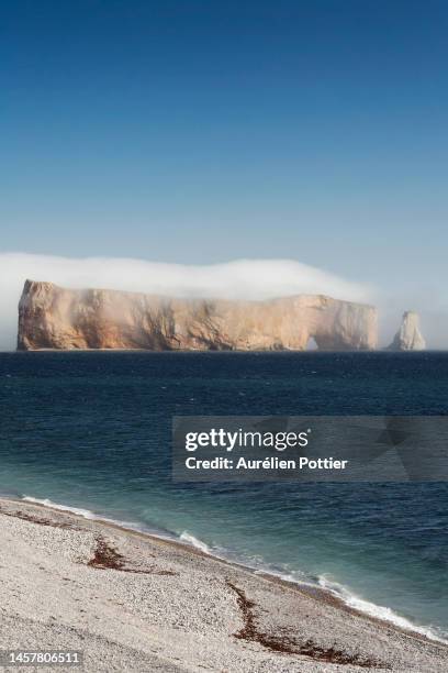 percé, the beach and percé rock covered in sea mist - gaspe peninsula stock pictures, royalty-free photos & images