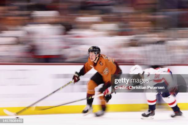 Barrett Hayton of the Arizona Coyotes skates with the puck ahead of Marcus Johansson of the Washington Capitals during the second period of the NHL...