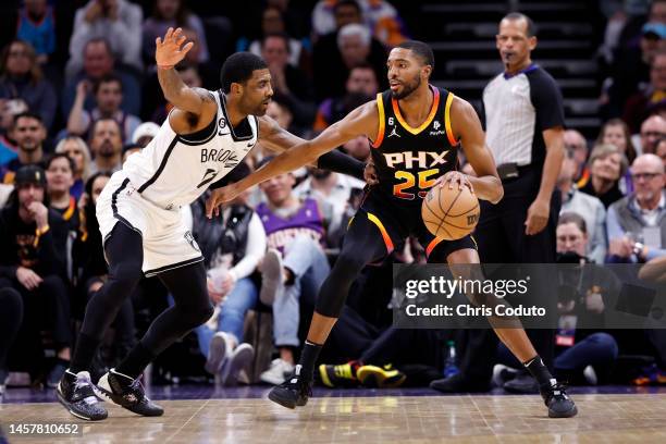 Mikal Bridges of the Phoenix Suns drives on Kyrie Irving of the Brooklyn Nets during the first half at Footprint Center on January 19, 2023 in...