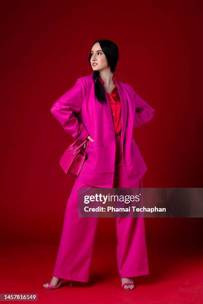 beautiful woman wearing pink suit - roter anzug stock-fotos und bilder