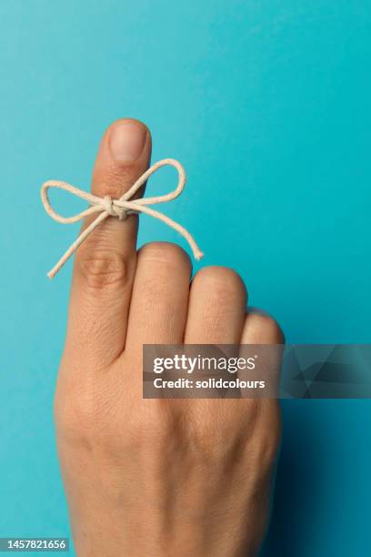 mano y cuerda atada en el dedo índice - index finger fotografías e imágenes de stock